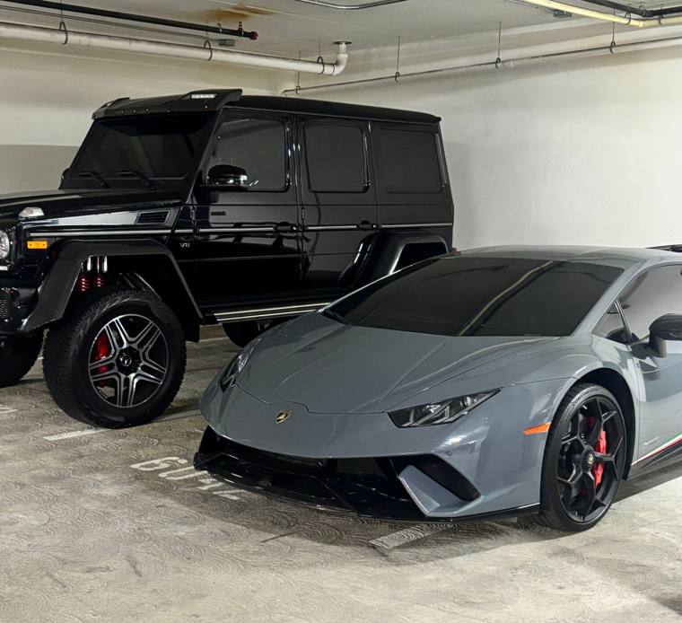 Black Mercedes G-Wagon and gray Lamborghini Huracán detailed in an Orange County parking garage